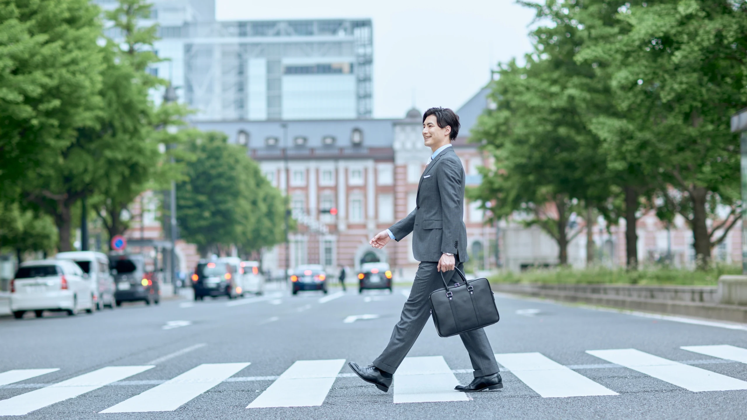 横断歩道を歩くスーツ姿の人物